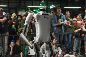 Ein Humanoider Roboter steht umringt von Menschen zur Schau.